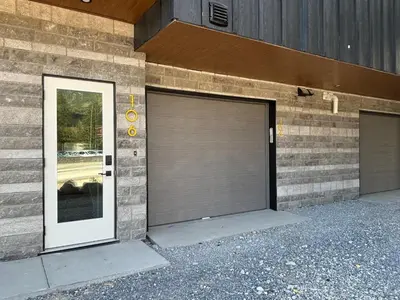 a building with two garage doors on the side of it at Ravens Peak - Private Hot Tub in Canmore