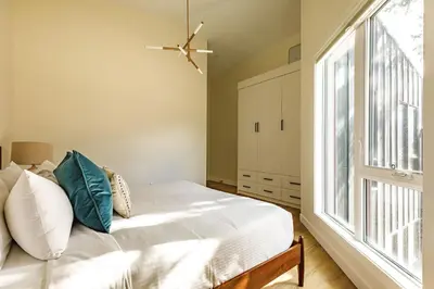 a bedroom with a bed and a large window at Ravens Peak - Private Hot Tub in Canmore
