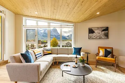 a living room with a couch and a table at Ravens Peak - Private Hot Tub in Canmore