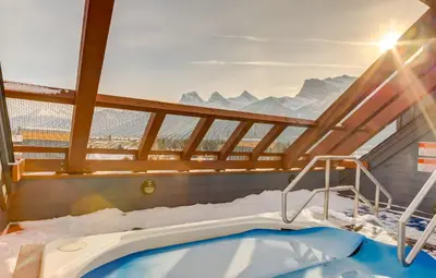 a jacuzzi tub in a room with snowy mountains at Valhalla - Pure Mountain Bliss in Canmore