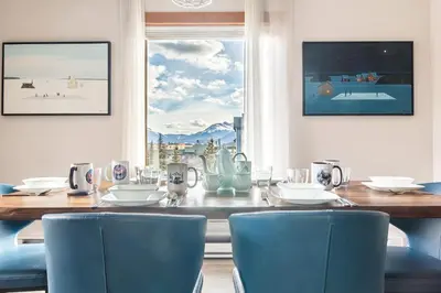 a dining room with a table and chairs and a window at Alpen Glow at Canmore Crossing in Canmore