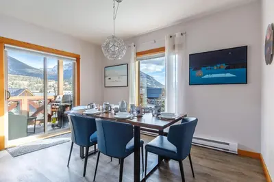 a dining room with a table and blue chairs at Alpen Glow at Canmore Crossing in Canmore
