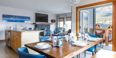 a kitchen and dining room with a table and chairs at Alpen Glow at Canmore Crossing in Canmore
