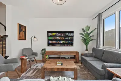 a living room with a couch and a table at Luxe Retreat with Gym, Ping Pong, King Bed, Near WEM in Edmonton