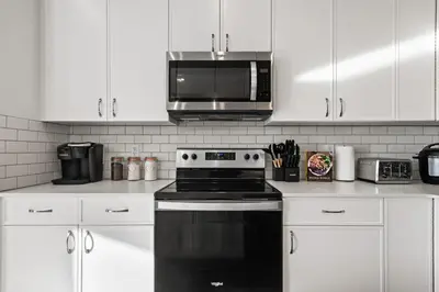 a kitchen with a black stove and a microwave at Luxe Retreat with Gym, Ping Pong, King Bed, Near WEM in Edmonton