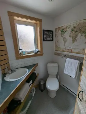 a bathroom with a toilet and a sink and a map at Yukon Sweet Spot Bed and Bakery in Whitehorse