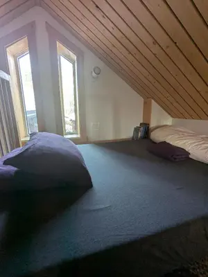 a attic room with two beds and two windows at Yukon Sweet Spot Bed and Bakery in Whitehorse