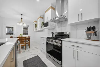 a kitchen with white cabinets and a stove top oven at Spacious 4 Beds Sleeps 8 Near Airport Family Home in Nisku