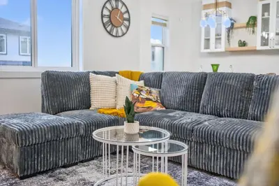 a living room with a couch and a table at Spacious 4 Beds Sleeps 8 Near Airport Family Home in Nisku