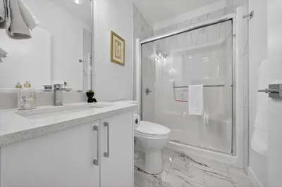 a white bathroom with a shower and a toilet at Spacious 4 Beds Sleeps 8 Near Airport Family Home in Nisku