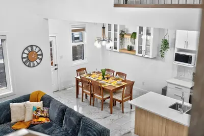 a kitchen and living room with a table and chairs at Spacious 4 Beds Sleeps 8 Near Airport Family Home in Nisku