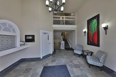 a hallway with two chairs and a painting on the wall at Ice District 2 Kings Private Parking Patio in Edmonton