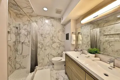 a bathroom with a shower and a toilet and a sink at Ice District 2 Kings Private Parking Patio in Edmonton