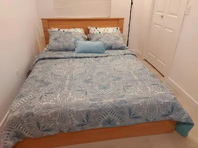 a bedroom with a bed with a blue comforter and pillows at 43 Erin Woods Drive SE Calgary in Calgary