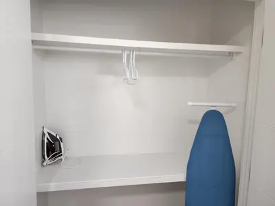 a white cabinet with a blue chair in a room at Cozy, Classy 2 BedRM Private Suite with Netflix and Parking in Edmonton