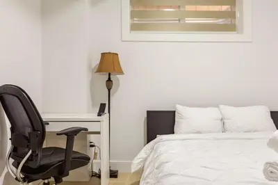 a bedroom with a desk and a chair next to a bed at Cozy, Classy 2 BedRM Private Suite with Netflix and Parking in Edmonton