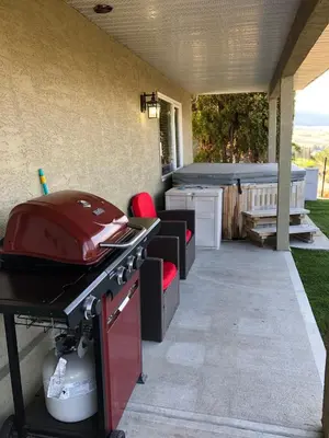 a patio with a grill and a hot tub at 20 KLM from SilverStar with private Hot Tub in Vernon