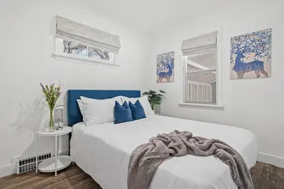a bedroom with a large white bed with blue accents at Blue Raptor Family-Friendly 3BR Private Yard in Drumheller