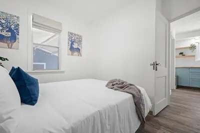 a white bedroom with a bed and a window at Blue Raptor Family-Friendly 3BR Private Yard in Drumheller
