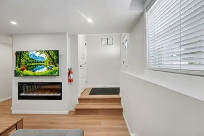a living room with a fireplace and a tv on a wall at Deluxe Mahogany Lake Getaway Sleeps 4 in Calgary