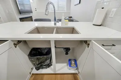 a kitchen with a sink in a white counter at Deluxe Mahogany Lake Getaway Sleeps 4 in Calgary