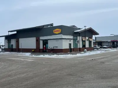 a building with a donut shop next to a parking lot at Deluxe 2-Bedroom Getaway Near Mahogany Lake in Calgary