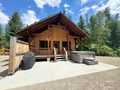 a log cabin with a tub at Mountaineer Creekside Cabin - Private Hot Tub in Golden
