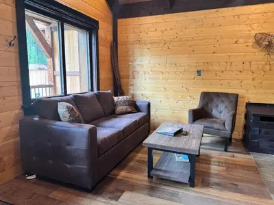a living room with a couch and a coffee table at Mountaineer Creekside Cabin - Private Hot Tub in Golden