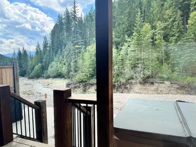 a view from the balcony of a house with a table at Mountaineer Creekside Cabin - Private Hot Tub in Golden