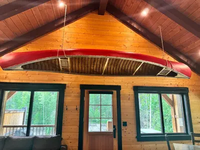 a surfboard hanging from the ceiling of a room at Explorer Creekside Cabin - Private Hot Tub in Golden
