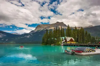 a lake with two boats on a dock in front of a mountain at Golden Moments in Golden
