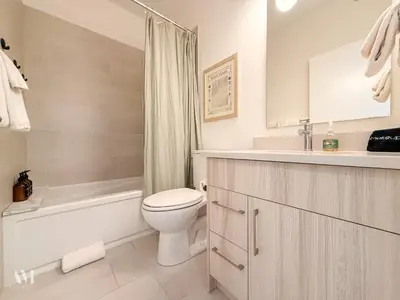 a bathroom with a toilet and a tub and a sink at Oso Skyview Suite - DT modern 2 bed, 2 bath in Golden