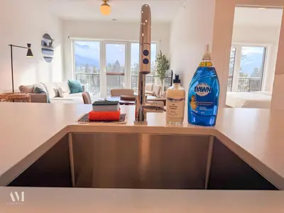 a kitchen sink with a bottle of cleaning products on it at Oso Skyview Suite - DT modern 2 bed, 2 bath in Golden