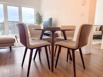 a table with four chairs and a computer on it at Oso Skyview Suite - DT modern 2 bed, 2 bath in Golden