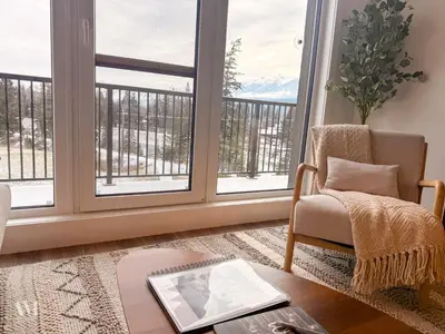 a living room with a chair and a window at Oso Skyview Suite - DT modern 2 bed, 2 bath in Golden