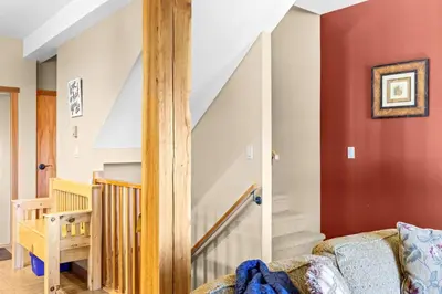 a living room with a staircase with red walls at Whispering Pines 3BR Townhouse Views and private Hot Tub in Golden