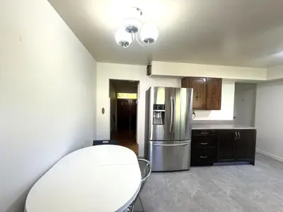 a kitchen with a stainless steel refrigerator and wooden cabinets at Richmond 6011 in Richmond