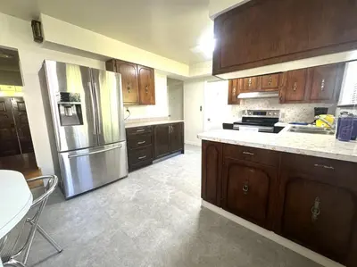 a kitchen with wooden cabinets and a stainless steel refrigerator at Richmond 6011 in Richmond