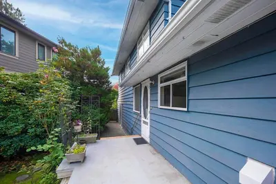 a blue house with a blue wall and a patio at Richmond 6011 in Richmond