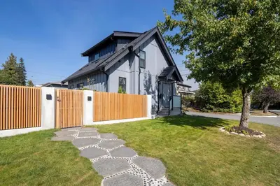 a house with a fence and a grass yard at Sunny 1BR Detached Suite - Near City Center in Vancouver