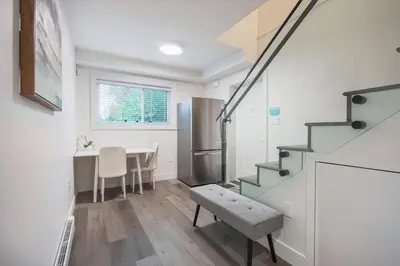 a kitchen and dining room with a staircase and a table at Sunny 1BR Detached Suite - Near City Center in Vancouver
