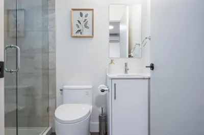a bathroom with a toilet and a sink and a shower at Sunny 1BR Detached Suite - Near City Center in Vancouver