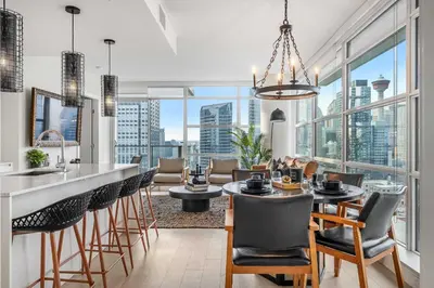 a kitchen and living room with a view of the city at Manhattan Right Next to Stampede Grounds DT in Calgary