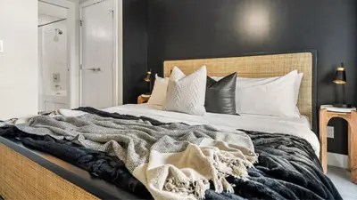 a bedroom with a large bed with black walls at Manhattan Right Next to Stampede Grounds DT in Calgary