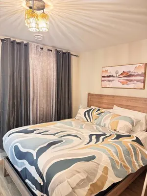 a bedroom with a bed and a chandelier at NorthEdge Suites in Edmonton
