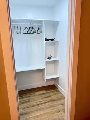 a closet with white shelves and glasses in it at NorthEdge Suites in Edmonton