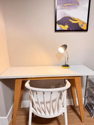 a white desk with a lamp and a chair at NorthEdge Suites in Edmonton