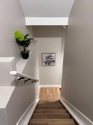 a hallway with white walls and a plant on the wall at NorthEdge Suites in Edmonton