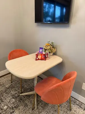 a table with two orange chairs and a table with a table at Lovely 2 bedroom suite in Langford in Metchosin