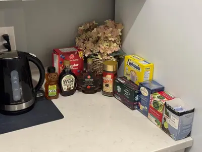 a counter with a bunch of food and a vase with flowers at Lovely 2 bedroom suite in Langford in Metchosin